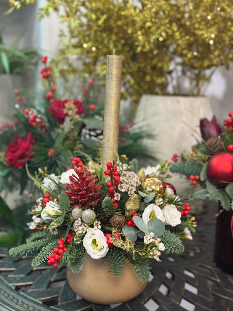 Centre de table de Noël élégant avec bougie dorée, roses blanches, baies rouges et sapin frais — Gladys Fleurs Bruxelles